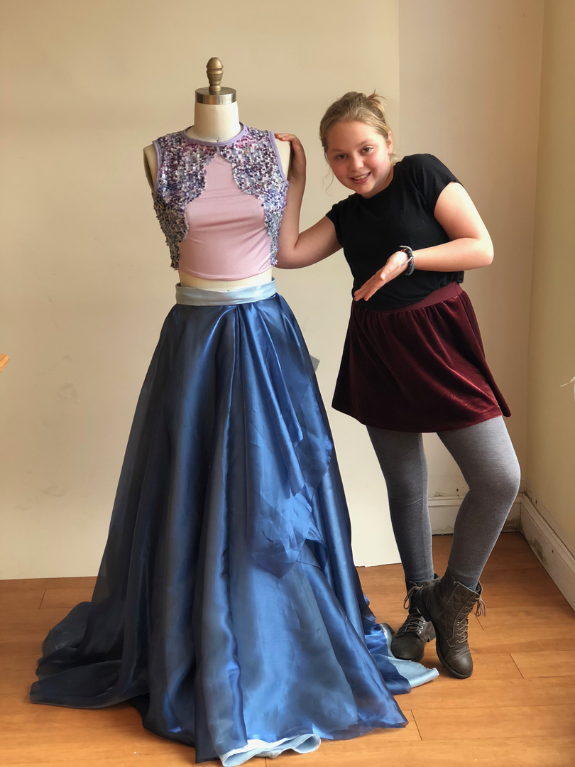A girl standing beside a mannequin adorned with beautiful coordinating pieces of clothing